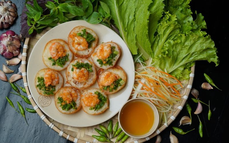 Đĩa bánh khọt tôm tươi ăn kèm rau sống và nước mắm